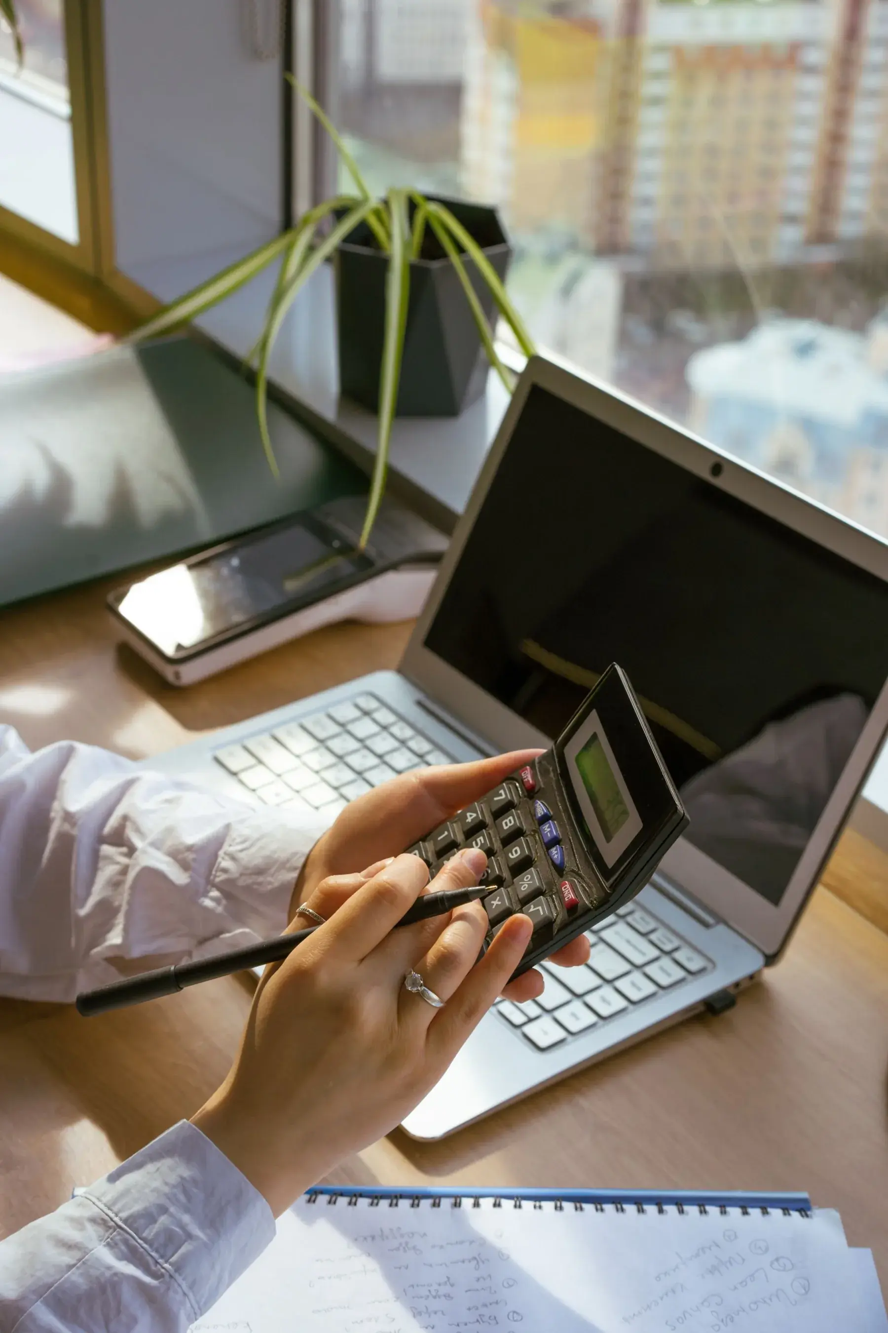 A calculator and laptop on a bright office desk, representing Edu Accounting & Auditors' accounting services