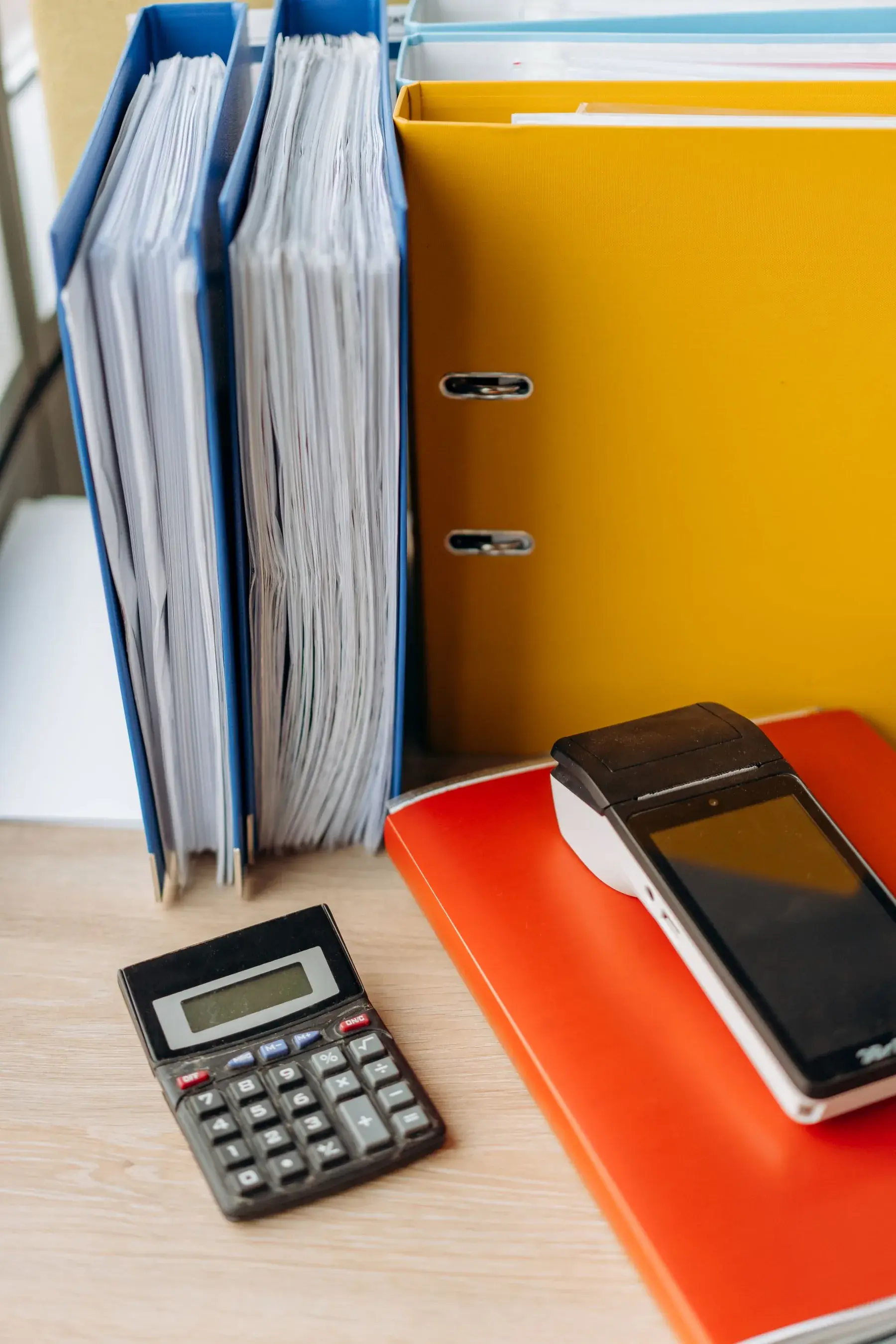 Organised office binders and a calculator on a desk, representing Edu Accounting & Auditors' bookkeeping services
